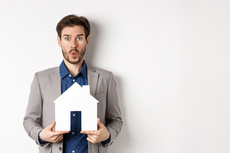 Makelaar met wit huis in hand