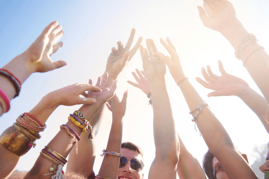 Groep vrienden handen in de lucht festival